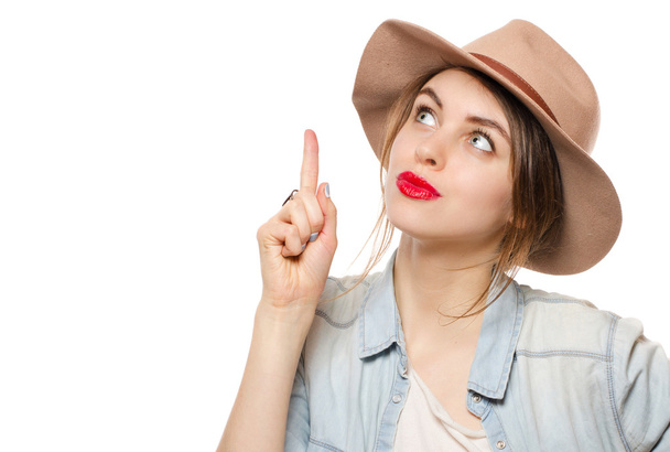 Beautiful young woman in hat  with finger point up have an idea - Foto, Imagen