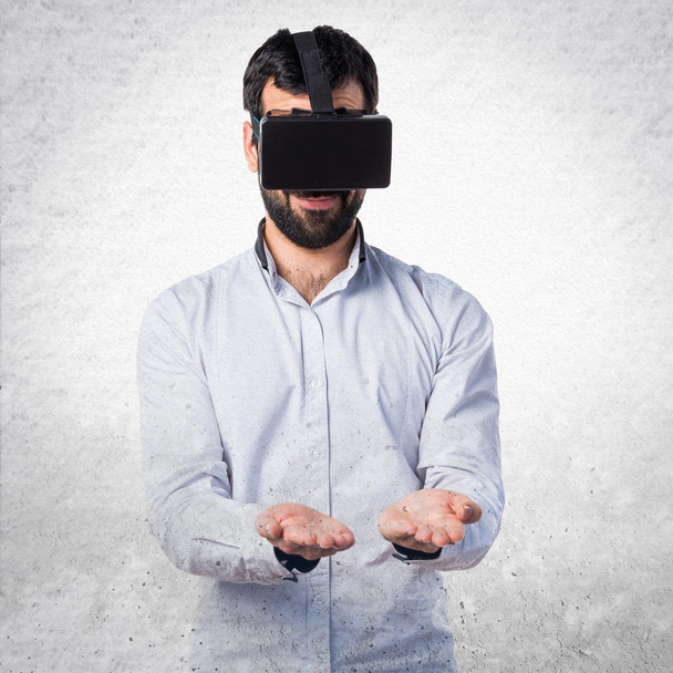 Homem usando óculos VR segurando algo
 - Foto, Imagem