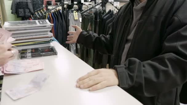 Man betaalt geld in contanten in de kleding winkel shop - Video