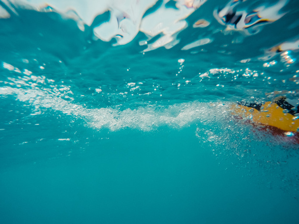 Подводный вид движущегося надувного кольца, плавающего в воде
 - Фото, изображение