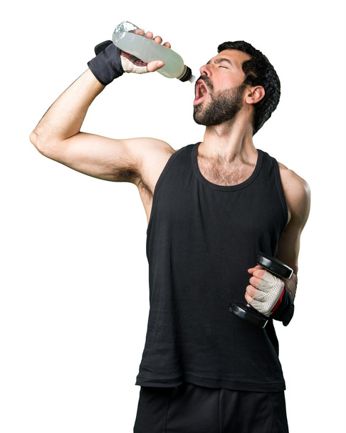Sportman doing weightlifting drinking water soda - 写真・画像