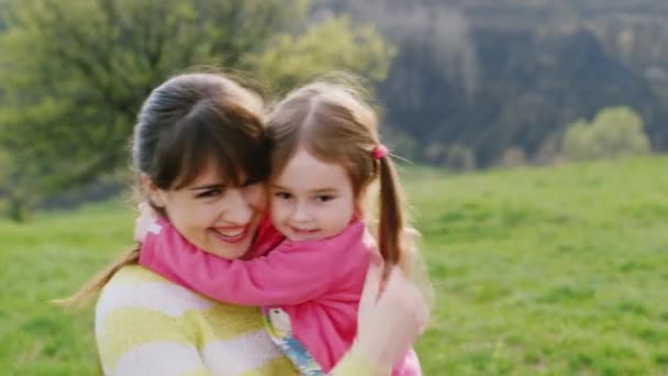 Chica 3 años abrazando y besando a su madre, jugando en el parque
 - Metraje, vídeo