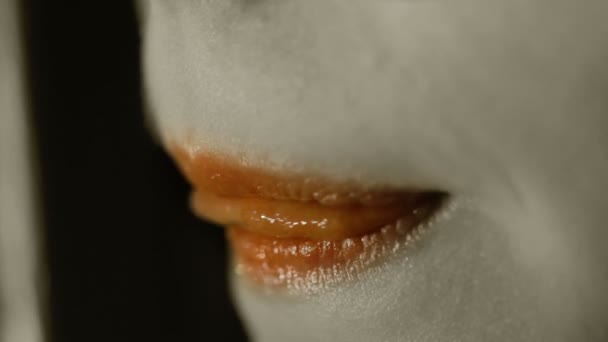 Lápiz labial naranja en la boca de la joven. Sexy chica joven lamiendo labios con lengua
 - Metraje, vídeo
