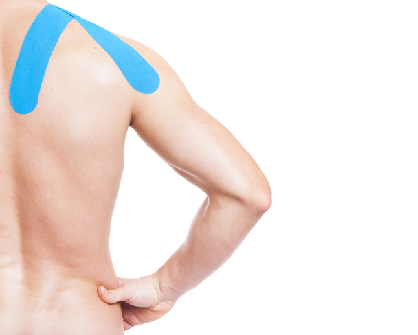 Muscular man with kinesiotaping on the shoulder - Foto, afbeelding