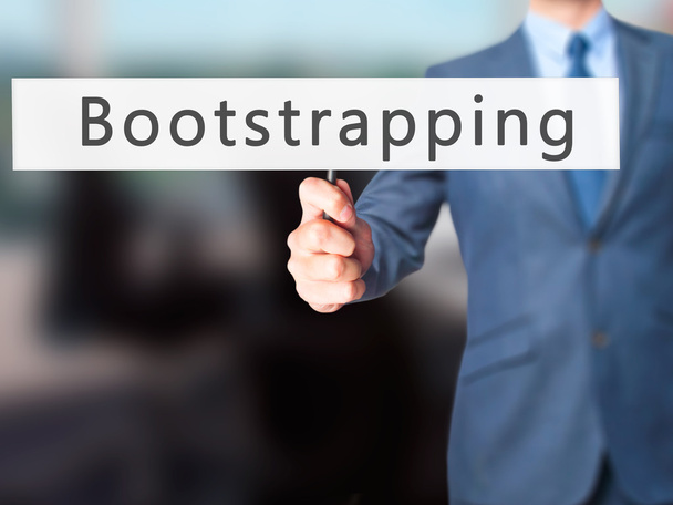 Bootstrapping - επιχειρηματίας χέρι κρατάει πινακίδα - Φωτογραφία, εικόνα