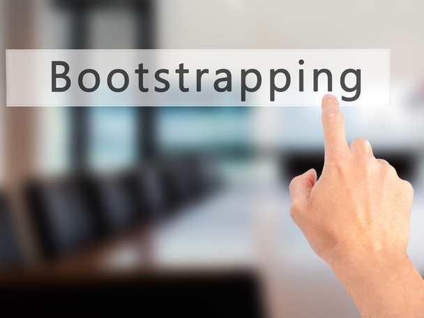 Bootstrapping - Mão pressionando um botão no fundo borrado con
 - Foto, Imagem