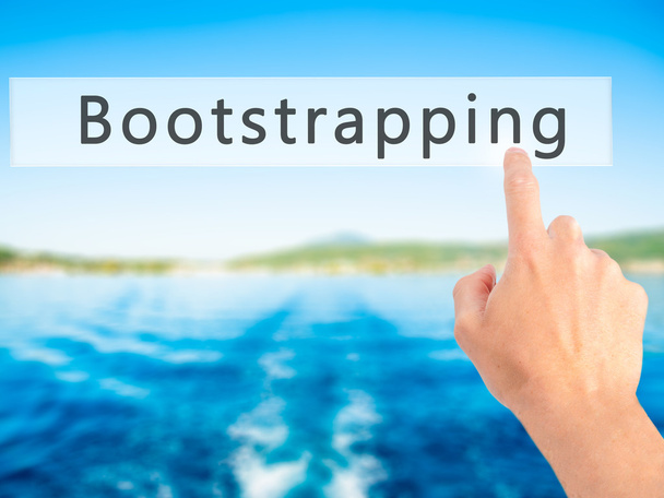 Bootstrapping - Mano premendo un pulsante su sfondo sfocato con
 - Foto, immagini