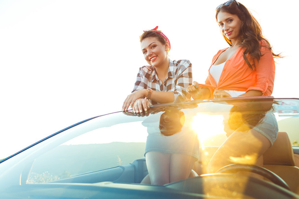 Deux jeunes filles heureuses s'amusent dans le cabriolet en plein air
 - Photo, image
