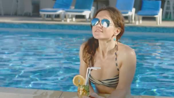 Pretty woman in bikini, sunglasses enjoys cocktail, pool party - Кадры, видео