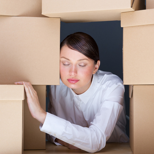Portrait of young woman surrounded by lots of boxes. Lots of wor - Foto, afbeelding