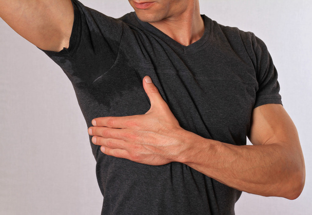 Sport man armpit sweating. Transpiration stain. Hyperthyroidism concept - Fotó, kép