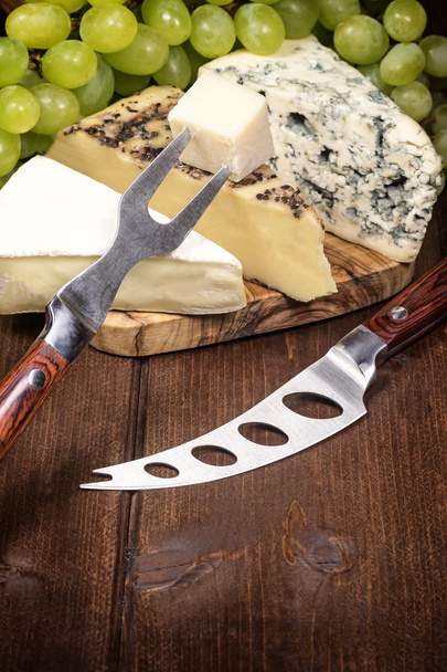 Cheese, grapes of the white wine, knife and fork - Фото, изображение