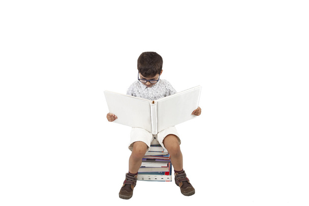 A halom könyvet elszigetelt fehér background ülő fiú - Fotó, kép