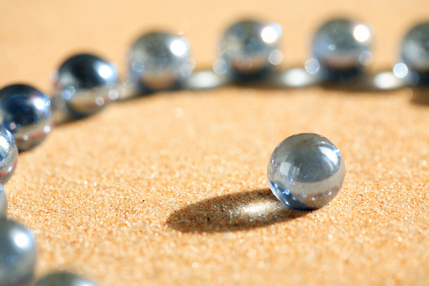 Bolas de vidro na areia
 - Foto, Imagem