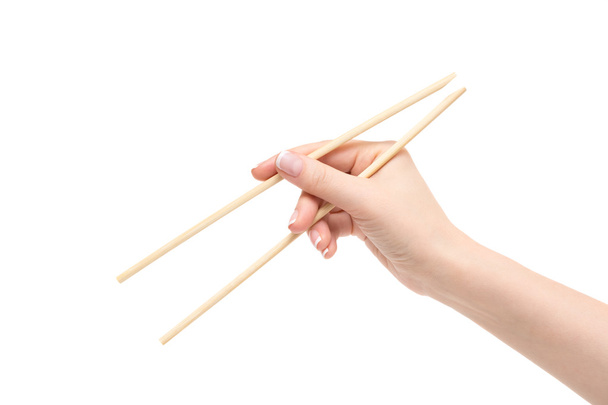 Female hand holds chopsticks on a white background. - Foto, imagen