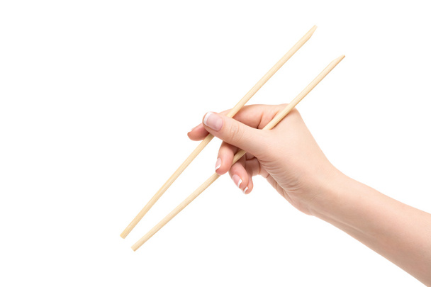 Isolated female hand holds chopsticks on a white background. - Foto, imagen