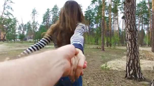 jovem mulher segurando homens mão e levando-o na natureza ao ar livre
 - Filmagem, Vídeo