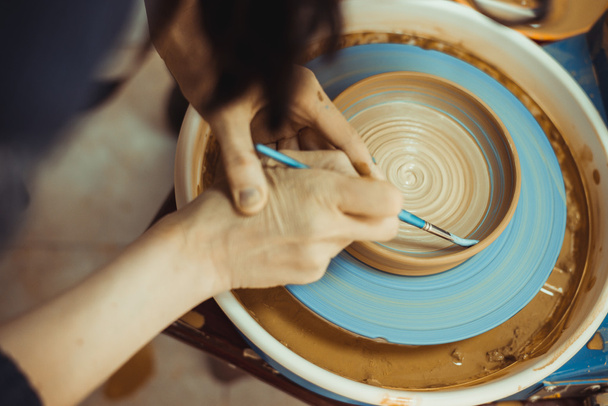 man paints a clay plate - Fotó, kép