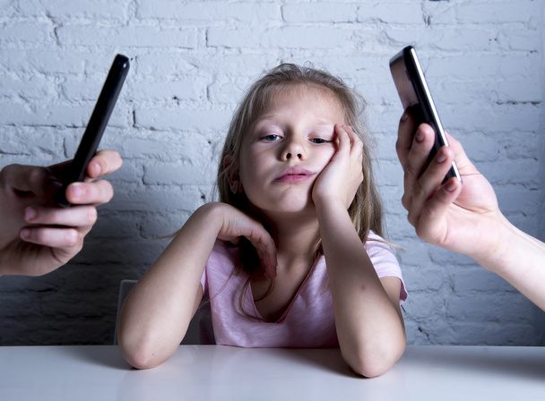 hands of network addict parents using mobile phone neglecting little sad ignored daughter bored - Foto, Bild