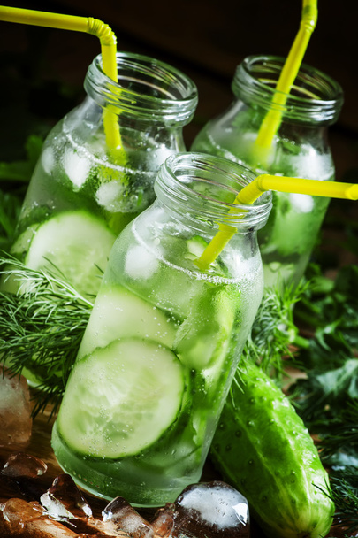Refreshing cold drink of cucumber and herbs in glass bottles - Fotoğraf, Görsel