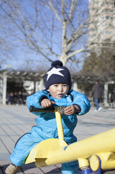 Söpö kiinalainen vauva poika pelaa seesaw ulkona
 - Valokuva, kuva