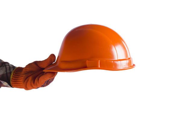 Hand holding out the construction orange helmet. - Foto, Bild