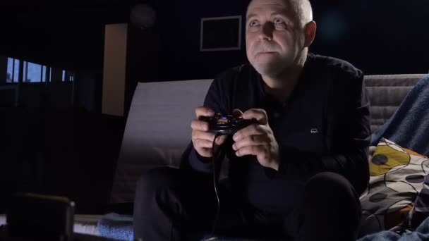 erwachsener Mann mit Spielkonsole in einem dunklen Raum Café mit Leidenschaft leidenschaftliches Computerspiel - Filmmaterial, Video