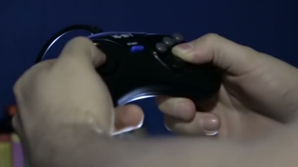 Mãos de um jovem com um console de videogame no fundo da tela de tv vai jogo de corrida sobre os carros
 - Filmagem, Vídeo