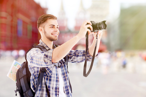 Traveler man with camera takes photo  - Фото, изображение