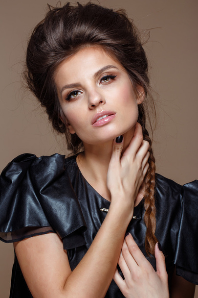Portrait of young beautiful woman in leather black  dress with natural beauty, nude makeup, hairstyle - Fotografie, Obrázek