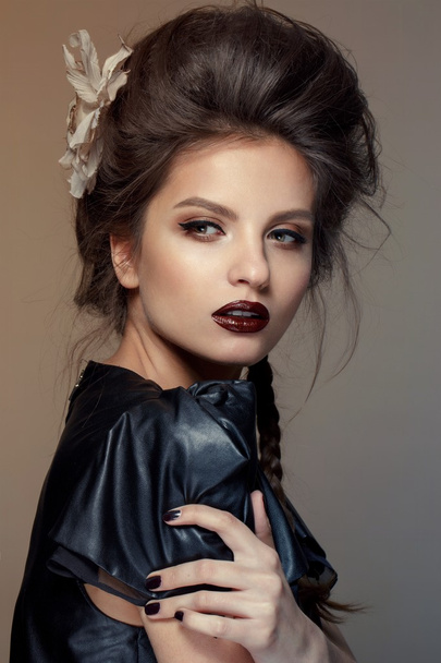 Portrait of young beautiful woman in leather black  dress with natural beauty, nude makeup, hairstyle - Fotó, kép