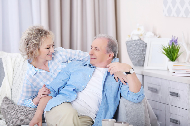 Mature couple sitting at home - 写真・画像