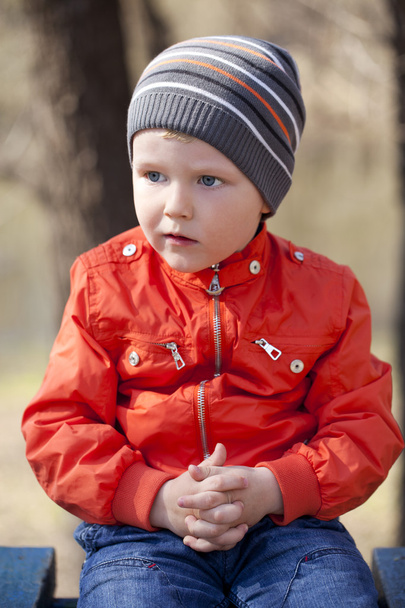 Niño en jaket naranja y jeans azules
 - Foto, imagen