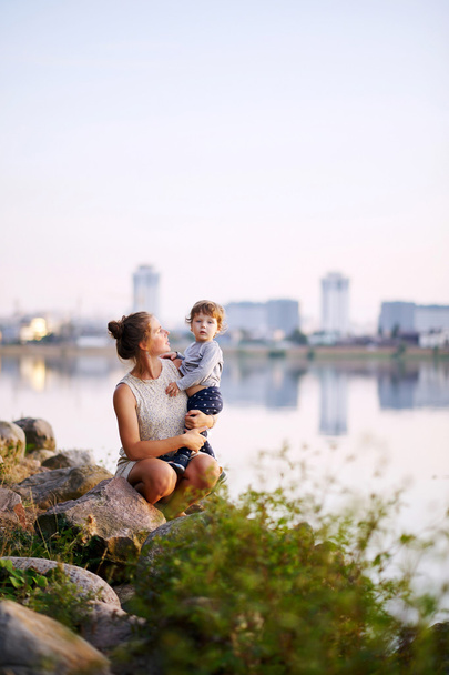 夏の公園で彼女の小さな息子と歩いて若い妊娠中の母親 - 写真・画像