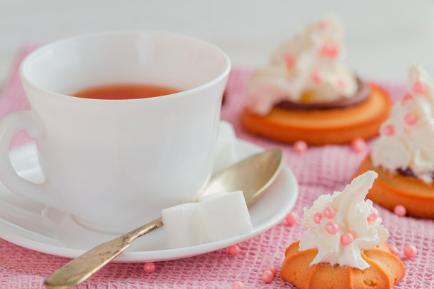 xícara de chá com colher de chá e bolos de biscoito
 - Foto, Imagem