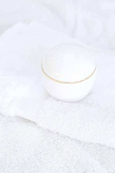 Cosmetic containers lying on white towel - Photo, image