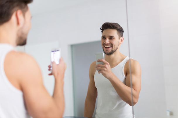 Man taking selfie in bathroom - Φωτογραφία, εικόνα