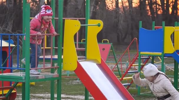Meisjes rijden een achtbaan op de speelplaats - Video