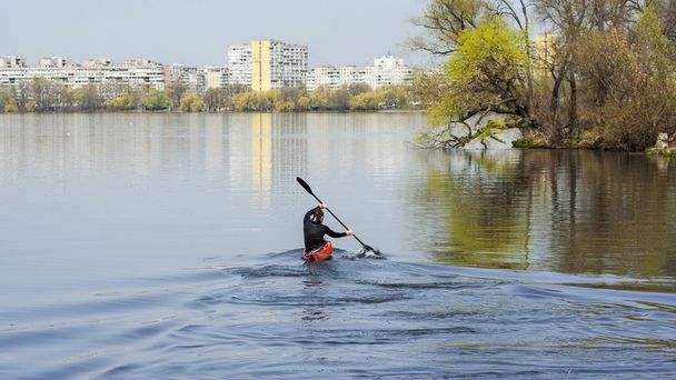 a man kayaking on a background of the city, turn to kayak - 写真・画像