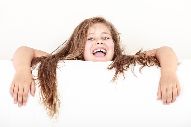 Маленькая девочка с длинными волосами держит пустой баннер
. - Фото, изображение