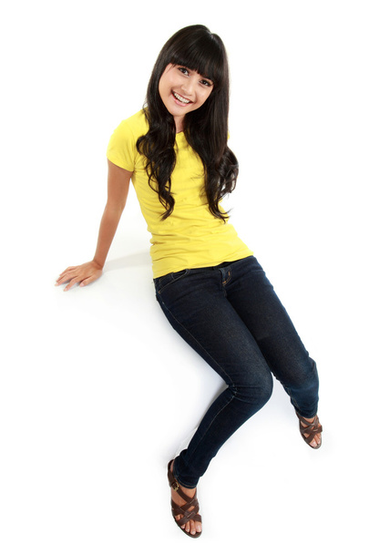 Asian girl in jeans sitting on the white table - Fotoğraf, Görsel
