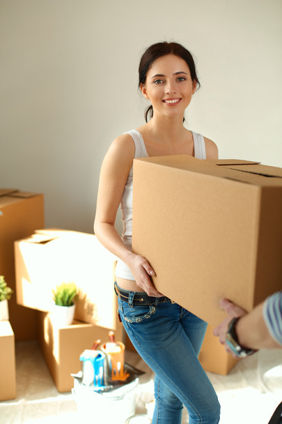 Happy young couple unpacking or packing boxes and moving into a new home - Fotoğraf, Görsel