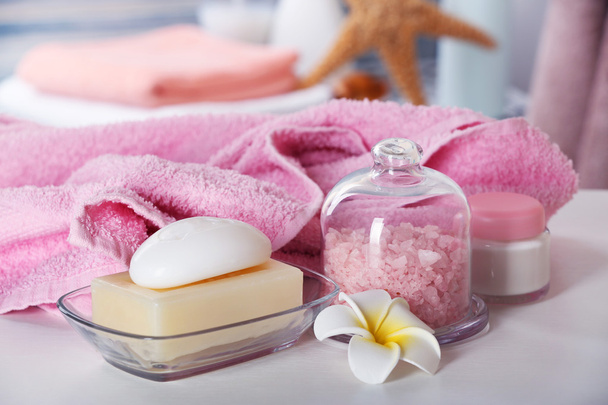 Pink towel with salt and soap on bathroom table - Zdjęcie, obraz