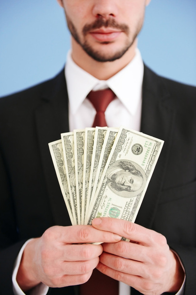 Man in een pak houden dollar biljetten - Foto, afbeelding