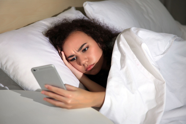 Sleepy girl with cellphone in bed - Photo, image