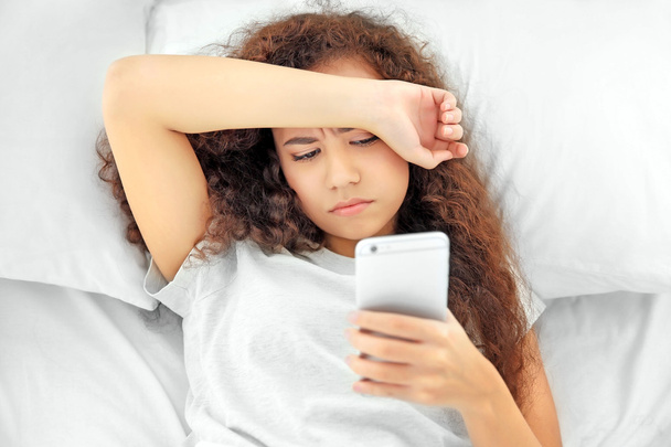 Beautiful sleepy girl in bed with cellphone - Foto, immagini