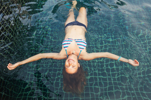 beautiful young woman in the pool, shot from above - Фото, изображение