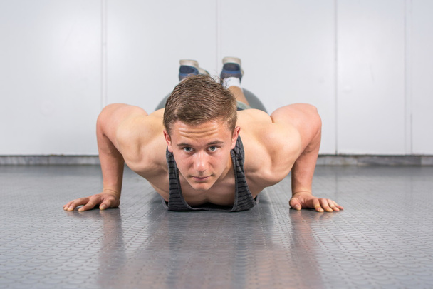 Mężczyzna wykonywania pompek na siłowni - Zdjęcie, obraz