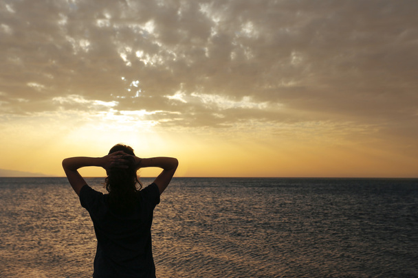 La silueta de mujer con puesta de sol
 - Foto, Imagen