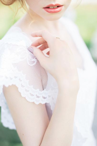 Close-up of bride in white laced dress - Foto, imagen